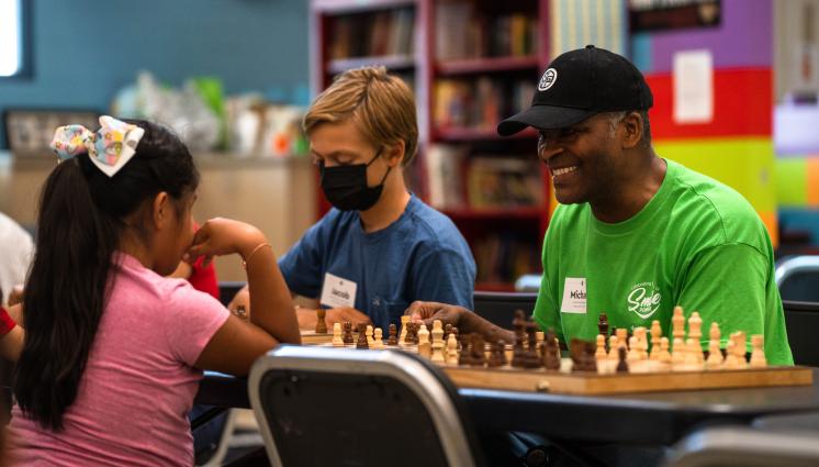 Volunteers bring joy and connection to our work. Volunteer playing chess