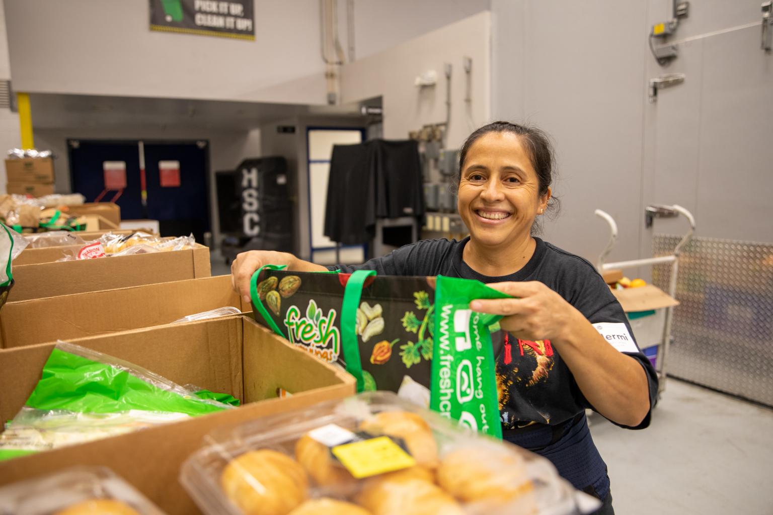 Guillermina-header Woman loading food into a bag