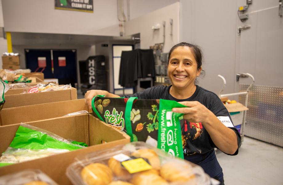 Guillermina-header Woman loading food into a bag
